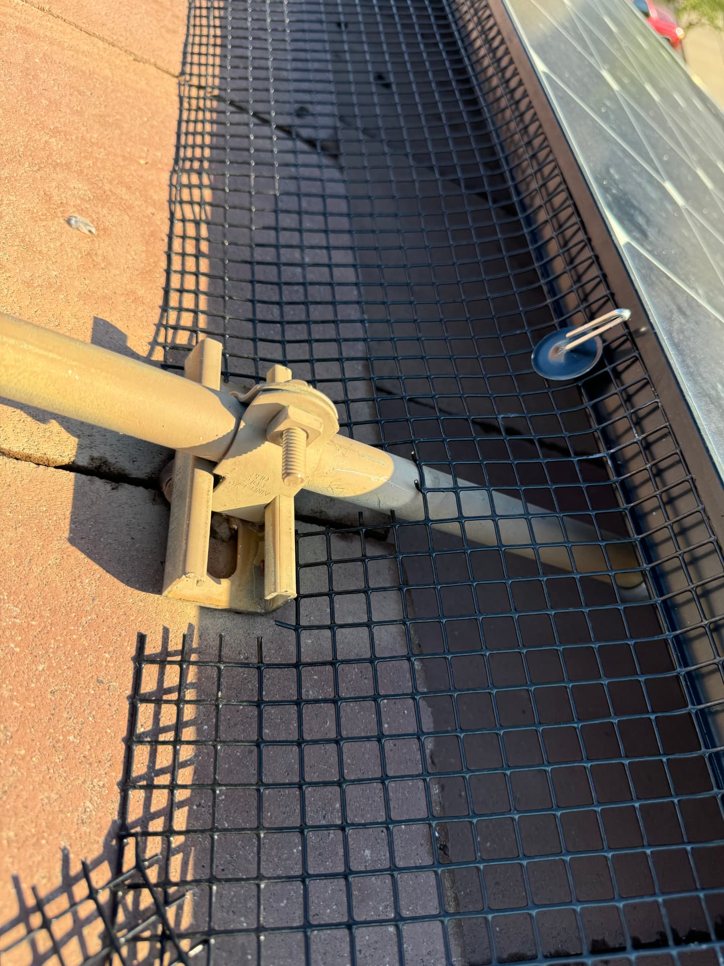 Black mesh pigeon barrier secured along the edge of a solar array