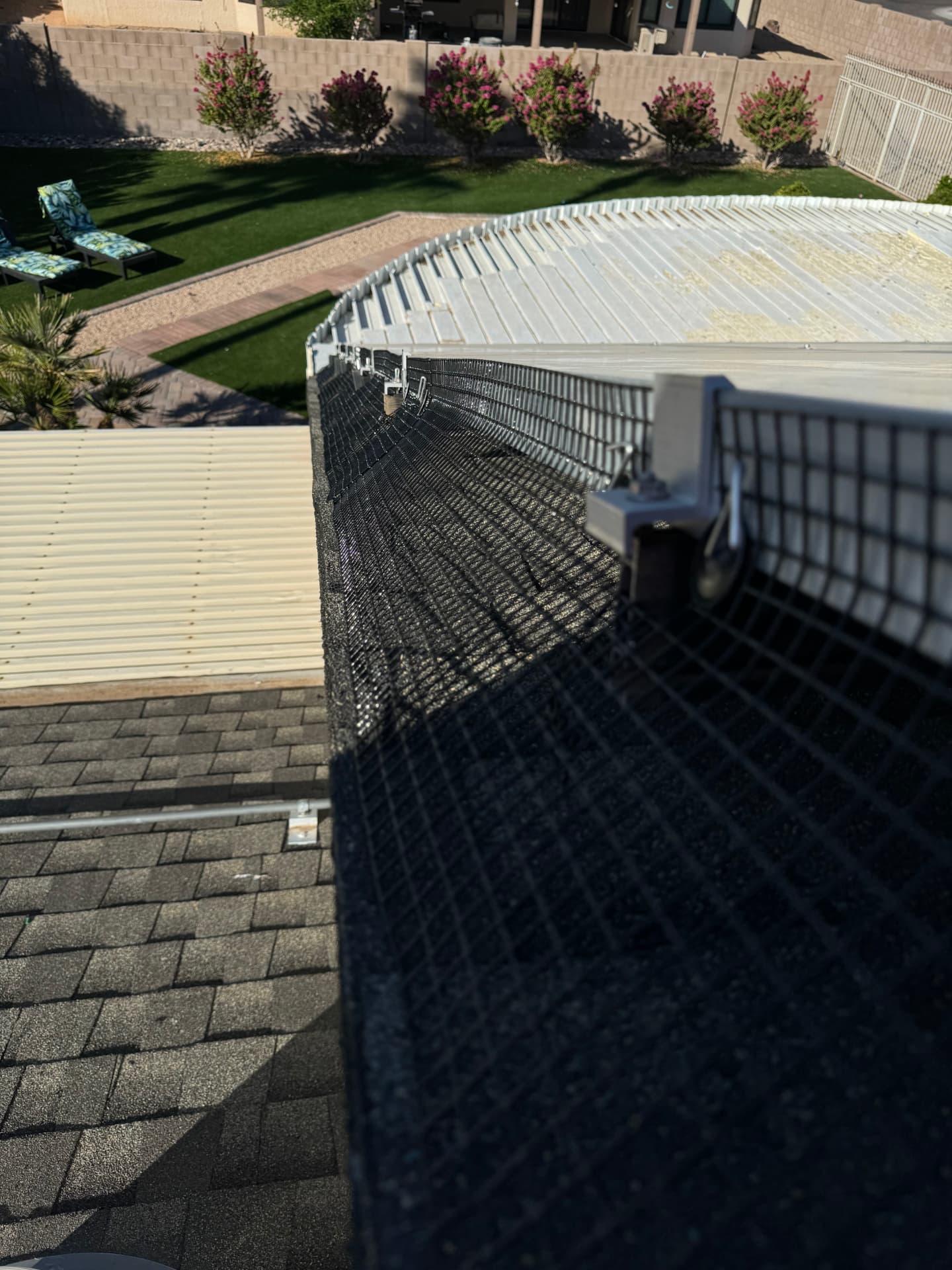 Mesh barrier wrapping the corner of a solar array above a backyard