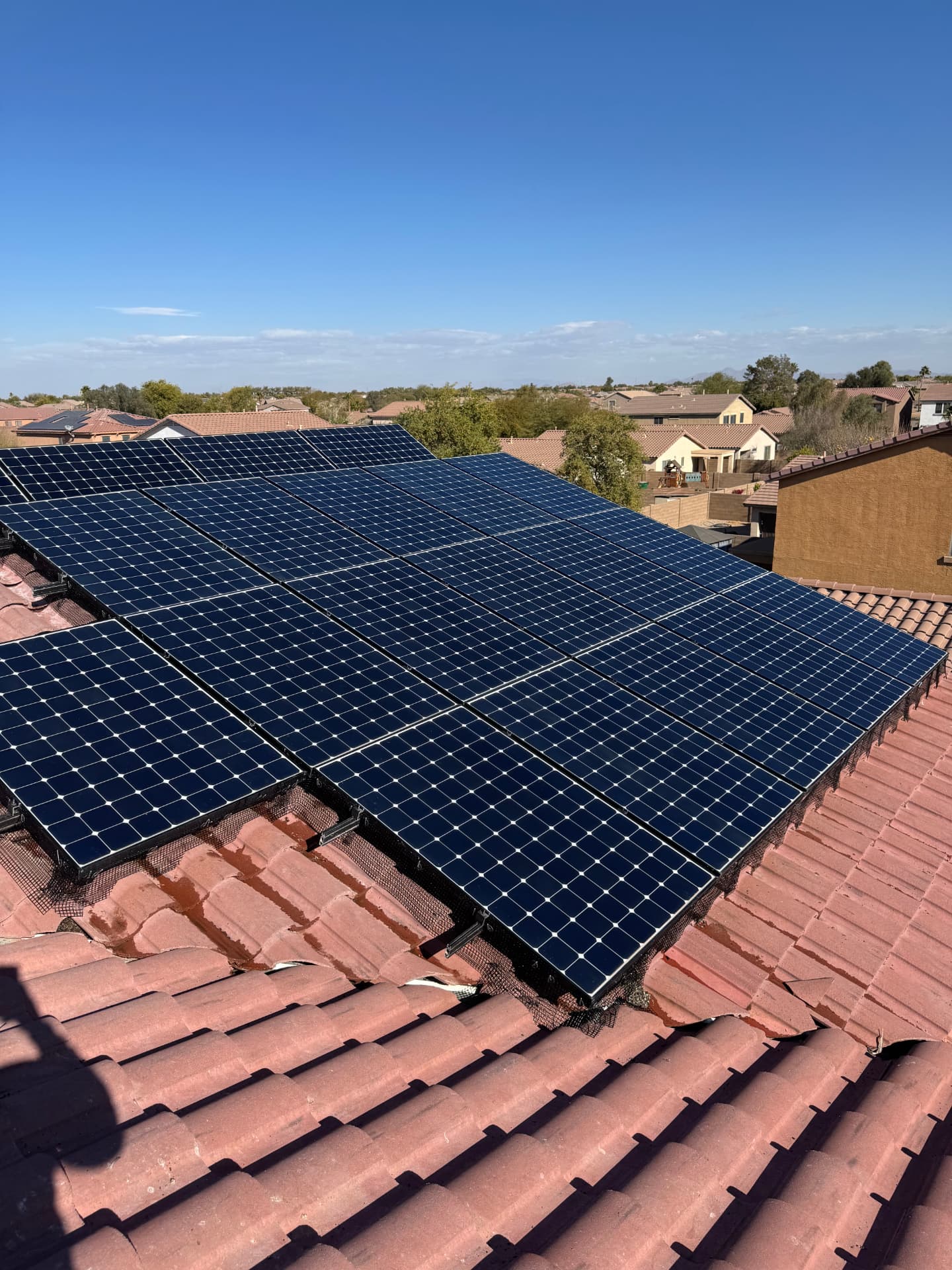 Bright blue solar panels on a clay tile roof after cleaning