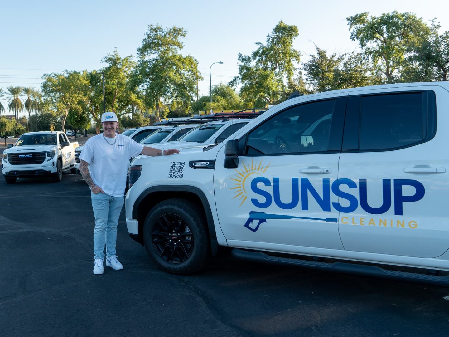 James Smiley, owner of SunsUp Cleaning, beside the SunsUp truck fleet